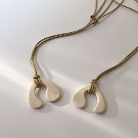 Stylish and minimal! This minimalist ceramic necklace is an organically created white color design with adjustable brown cords. We try to convey the naturalness of the material by preserving the raw state of handmade products. You can feel the natural texture of ceramic. The necklace is adjustable and knotted to the ideal length. It is very comfortable and light to wear. We design and handcraft each piece in our own studio. It is designed as a stylish gift for your loved ones on special occasion Ceramic Necklaces, Handmade Ceramic Jewelry, Clay Works, Pottery Inspo, Hanging Necklaces, Cerámica Ideas, Ceramic Inspiration, Ceramic Necklace, Company Gifts