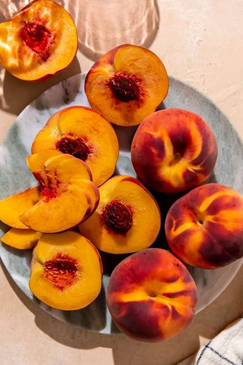 Fresh peaches cut in half and sliced. Tn Aesthetic, Peaches Photography, Peach Photography Aesthetic, Peach Food Photography, Peaches Aesthetic, Peaches Aesthetic Fruit, Bowl Of Peaches, Peach Leaves, Peach Fruit Photography