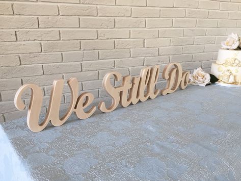 "We still do sign - script letters for table top decoration for any wedding, Anniversary, or vow renewal. Freestanding wood sign décor, wedding sign, rustic sign. Anniversary gift, wedding present. Available painted, unpainted, with distressed edges, glittered or with silver or gold dust on the front of the letters. The sign on the photos in this listing is UNPAINTED. The sign is cut from 3/4\" plywood and will arrive on 3 elements: We Still Do --- --- --- --- -- --- -- --- HOW TO ORDER? --- --- Vowel Renewal Ceremony, 25 Wedding Anniversary Decorations, We Still Do, Vow Renewal Decorations, 10 Year Wedding Renewal, Vowel Renewal Dress, Wedding Renewal Ideas 10 Year, Wedding Anniversary Dress, We Still Do Sign