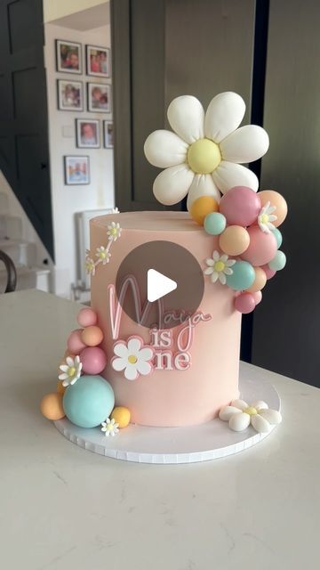 Claire Lawrence Cake Design on Instagram: "Cute Daisy themed cake for Maya’s first birthday 🥰 

Acrylic charm: @rowanandcocreative 
Colours: @cocoa.colour 
Board: @olbaa_cake_box 
Sugarpaste: @couturesugarpaste 

#cakedecorating #cakereels #cakevideos #daisycake #firstbirthdaycake #caketutorials #kentcakes #londoncakes #cakedesign" Colourful First Birthday Cake, First Birthday Cake Daisy, Cake Designs For First Birthday, Daisy Themed Birthday Cake, Toddler Girl Birthday Cake, Daisy First Birthday Cake, Daisy Themed Cake, Daisy Cake Birthday, Daisy Theme Birthday