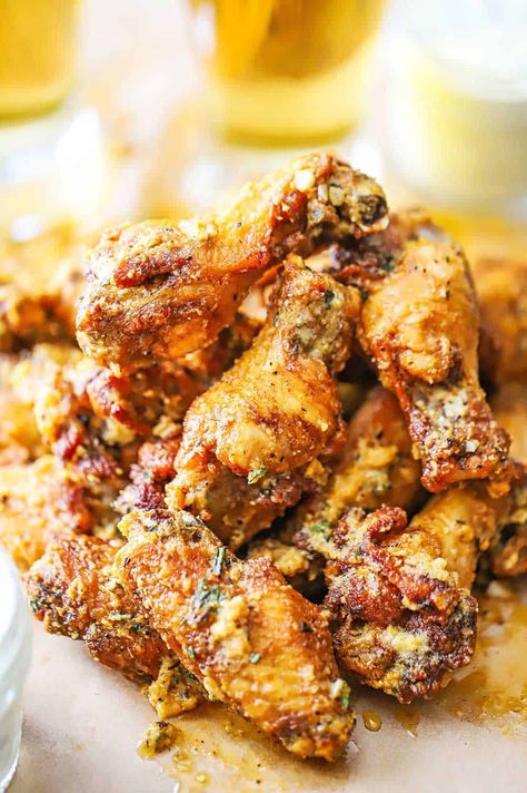 A pile of garlic Parmesan wings sitting on a piece of brown paper with two glassed of beer in the background. Wings Flavors, Homemade Blue Cheese Dressing, Homemade Blue Cheese, Wings Recipe Baked, Wings Recipes, Parmesan Wings, Garlic Parmesan Wings, Wing Sauce Recipes, Parmesan Chicken Wings