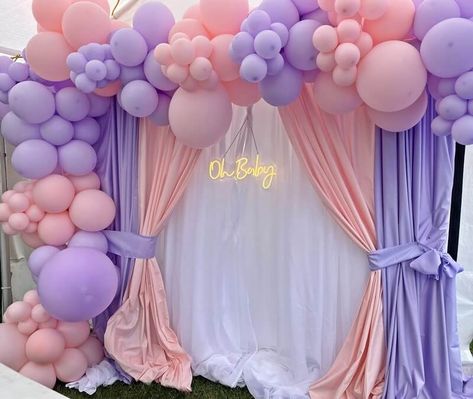 Give your baby shower party ambiance an endearing look and feel by setting up a sweet blush & lavender party backdrop. Set a sturdy backdrop stand and stylishly hang white, blush, & lavender polyester curtain panels to give your party backdrop a charming appeal. Highlight the adorability of your party backdrop by decking it with a blush & lavender balloon garland and hang ‘oh baby’ neon light sign to add funky vibes and festive lights into your baby shower party décor. Lavender Balloon Garland, Lavender Balloons, Lavender Party, Event Decor Ideas, Party Decorations Table, Backdrop Decor, Shower Backdrop, Decorations Table, Baby Shower Backdrop