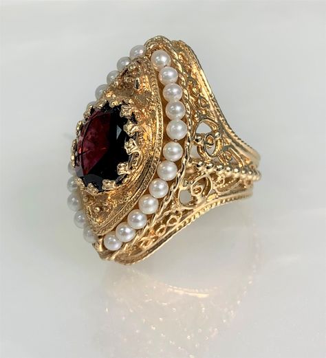 Garnet Ring, Garnet Jewelry, Garnet Engagement Ring, Garnet Ring for Women, Garnet Ring Vintage, Vintage Seed Pearl Ring, Garnet Gold Ring, Gemstone Ring Vintage An eye- catching regal vintage garnet ring featuring an oval shaped center stone weighing approximately 4.00 carats accented by 24 round seed pearls set in solid 14k yellow gold with intricate detailing.  *Ring size: US 7 3/4 *Ring weight: 15.15 Grams *Ring façade: 33X19mm *Center stone dimensions: 12X10mm Vintage Rings For Women, Unique Vintage Jewelry, Vintage Garnet Jewelry, Gold Ring With Ruby Stone, Gold Garnet Ring, Intricate Jewelry, Vintage Pearl Engagement Ring, Rings Vintage, Medieval Ring