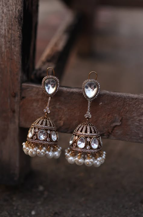 Illuminate your style with our Victorian Polki Jhumka Earrings, designed to radiate light and glamour. Embellished with reflective polkis, these earrings evoke the enchanting atmosphere of a starlit night, with a subtle shimmer that adds a touch of sparkle to any room. Perfect for adding a touch of elegance and sophistication to your look, these earrings are a must-have accessory for any occasion. Finish: 22KT Gold Plating Material: Silver, Copper Alloy, Polki, Pearls Color: Gold Size: One Size Jhumkas Aesthetic, Polki Jhumkas, Desi Earrings, Pearl Jhumkas, Radiate Light, Starlit Night, Silver Jhumkas, Hand Jewelry Rings, Pretty Jewelry Necklaces