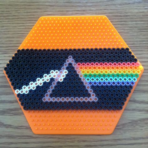 my version of pink floyd's iconic dark side of the moon album cover. the large hexagon perler board really helps.   got the board from amazon. they sell a box of large peg boards. includes several hexagons, squares, and circles. costs $16 USA. search for 'b00318in3o'. Wakaan Logo Perler, Pink Floyd Perler Beads, Perler Hexagon Pattern, Perler Bead Patterns Hexagon Board, Perler Bead Patterns Circle Board, Album Perler Beads, Space Perler Bead Patterns, Perler Door Hanger, Album Cover Perler Beads