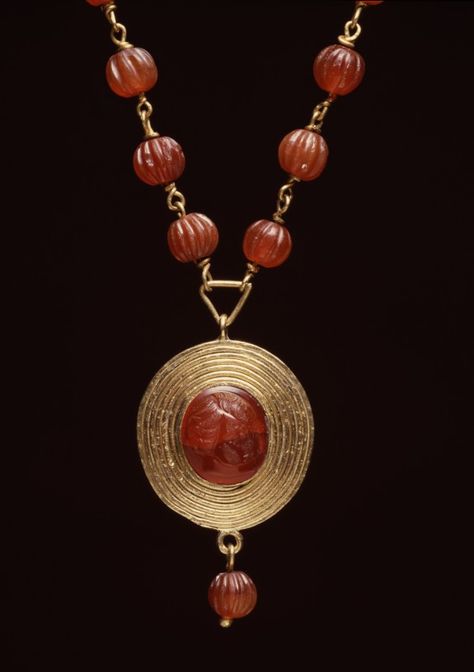 1st century BC-AD 1st century (Imperial (Roman) (?))  gold, carnelian. Necklace with Child's-Head Pendant. This necklace is a pastiche. The carnelian beads are ancient and strung on modern gold links. The lion-head finials comprising the hook and eye clasp are reused from Greek earrings. The child's head boldly carved in a carnelian stone is set in a gold setting, which may or may not be ancient. Roman Jewellery, Roman Necklace, Imperiul Roman, Ancient Necklace, Ancient Roman Jewelry, Ancient Jewels, Roman Jewelry, Ancient Jewellery, Historical Jewellery