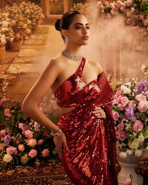 The Burmese ruby red sequin one-shoulder blouse dazzles with its radiant shimmer and bold design, perfectly paired with the intricate diamonds from Manish Malhotra High Jewellery, creating an unforgettable blend of refined opulence and elegant allure. Sequin Indian Outfit, Manish Malhotra Outfits, Shimmer Outfit, Red Sequin Saree, Cocktail Outfits, Selena Gomez Hair, Unique Saree, Heavy Lehenga, Saree Styling