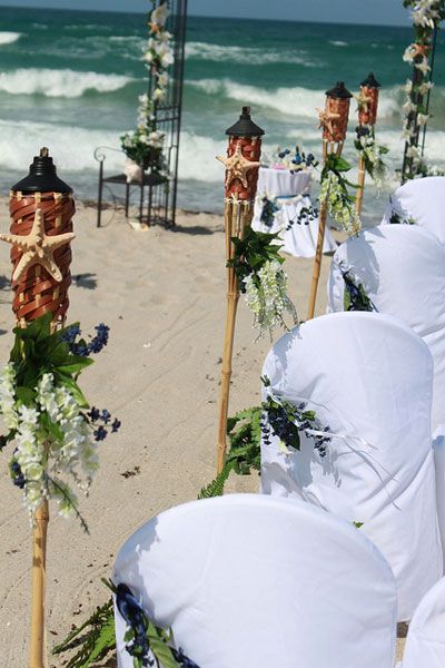 Tiki torches as aisle decor for beach wedding Wedding Tiki Torches, Isle Decor, Torches Tiki, Tiki Wedding, Seaside Party, 83rd Birthday, Silk Wedding Flowers, Wedding Dresses Videos, Diy Wedding Table