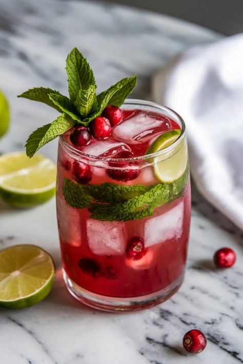 A photo of a  Cranberry Mojito a Cranberry Cocktails Christmas Mojito Vodka, Cranberry Mint Cocktail, Cranberry Lime Cocktail, Cranberry Mojito Recipe, Cranberry Juice Recipes Drinks, Cranberry Mocktail Recipe, Festive Mojito, Holiday Mojito, Cranberry Limeade