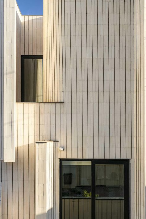 The sculptural form of this modern house is covered in tiles, giving it a unique appearance on the street. Sulaymaniyah City, Tiles Facade, Brick Pattern Tile, Stone Feature Wall, Small Terrace, Curved Walls, Brick Facade, Vertical Lines, Brick Patterns