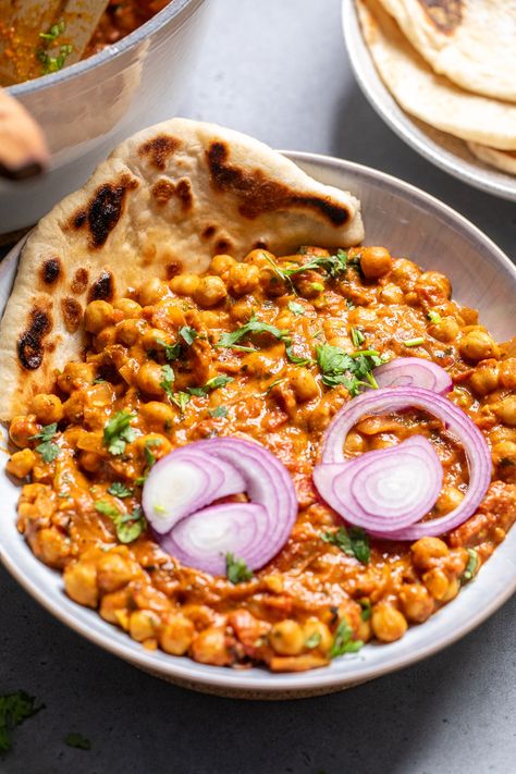 vegan chana masala in a bowl with naan on the side and topped with red onions. Protein Entrees, Vegan Chana Masala, Indian Chickpea Curry, Chana Masala Recipe, Spicy Thai Noodles, Vegan Chickpea Curry, Vegan Indian Recipes, Alkaline Vegan, Indian Dinner