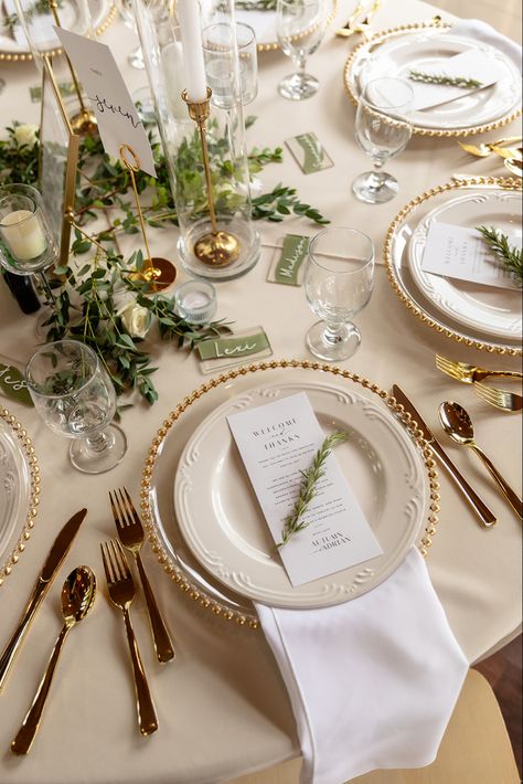 Classic gold trimmed chargers, flatware, candlesticks and greenery tablescape Gold Cutlery Wedding Place Settings, Plate Decor Wedding, Destination Wedding Tablescape, Place Setting With Charger, Silverware Placement On Table, Plate Chargers Ideas Place Settings, Wedding Place Settings Gold Charger, Green White And Gold Wedding Table Decor, White And Gold Wedding Table Setting