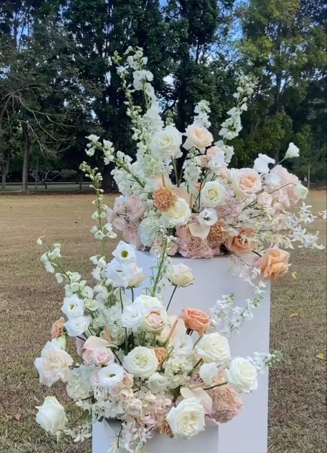 Pink And White Ceremony Flowers, Wedding Ceremony Podium Flowers, Pastel Flower Arrangements Wedding Ideas, White Green And Peach Wedding Flowers, White Blush Peach Wedding Flowers, Wedding Ceremony Pillar Flowers, Ceremony Flower Pillars, White And Peach Wedding Decor, Grounded Flower Arch