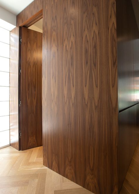 Does your door ruin the sleek look of the wall? Bookmatched walnut paneling conceals the flush powder room door. We decided to install a standard lever handset for fear that guests wouldn't find the powder room with no visible hardware on the door. 

#HomeBuilder #luxuryhomes #Toronto #renovations #remodeling #HomeAddition #construction #wholehomerenovation Century Home Renovation, Modern English Interior, Powder Room Door, Jib Doors, Walnut Paneling, Bold Front Door, Hidden Doors In Walls, Cali House, Hidden Doors