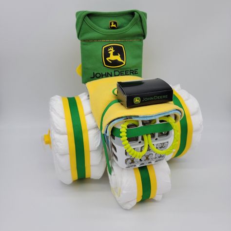 John Deere Tractor Diaper Cake (Traditional Colors) Ingredients: 30-40 Diapers 1 Dishwasher Basket 1 John Deere Onesie (Other John Deere Shirts Or Onesies May Be Substituted Based On Availability) 1 Bandana Or Other Coordinating Item To Cover Dishwasher Basket 2 Toy Rings 1 Baby On Board Sign. You May Choose A Plush Animal Driver Or An Extra John Deere Item (Usually Socks) For Your Order. Made To Order. *** This Exact Diaper Cake Has Sold But I Have Similar Materials Available As Well As Pink Jd John Deere Baby Door Hanger, John Deere Party Favors, Tractor Diaper Cake, John Deere Nursery Baby Boy, Deer Baby Shower Decorations, John Deere Nursery, Cover Dishwasher, Toy Rings, Tractor Diaper Cake Tutorial