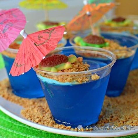 Tropical turtles on a sandy graham cracker beach in these cute and fun blue raspberry Jello cups for kids. They're a fun dessert idea for a summer parties. Jello Cups For Kids, Kids Luau, Raspberry Jello, Tropical Turtle, Lila Party, Jello Cups, Tropical Birthday Party, Island Party, Luau Theme Party