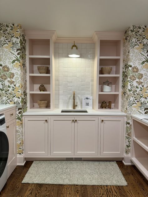 We are absolutely obsessed with this adorable and fun laundry room, featuring pastel pink cabinetry and built-ins, white tile backsplash, and a beautiful floral print wallpaper!!    New Construction | Home Trends 2024 | Home Design | Minnesota Home Trends Whimsical Laundry Room, Perfect Laundry Room, Pink Laundry Rooms, Floral Print Wallpaper, White Tile Backsplash, Minnesota Home, Exp Realty, Construction Home, White Tiles