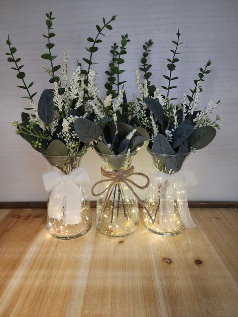 Cheap Wedding Table Centerpieces Simple, Vase Fairy Lights, Eucalyptus Beach Wedding, Fairy Light Glass Vase Centerpiece, Olive Green Centerpieces Wedding Ideas, Eculyptus Table Centerpieces, Table Centerpieces For Baby Shower Boys, Sage Green And Gold Centerpieces, Milk Jar Centerpieces