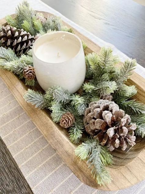 a Christmas centerpiece of a dough bowl with evergreens and pinecones plus a candle in a glass Wooden Bowls Centerpiece, Winter Centerpieces For Table, Diy Christmas Village Displays, Dough Bowl Centerpiece, Cozy Holiday Decor, Christmas Tree Inspo, Winter Centerpieces, Christmas Bowl, Christmas Homescreen