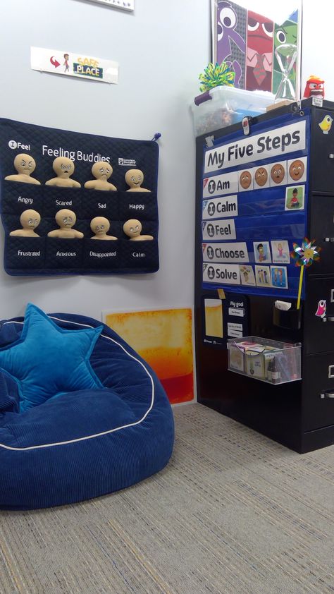 Safe Spot- Calming area for students in my elementary counseling office. I used the side of a large filing cabinet in the back of my office.  The orange "surf" board can pressed w/hands or stompped on OR turn it to watch the water fall.  Favorties: Blowing pinwheel, sented lotion, breathing w/Hoberman's sphere, magnetic hourglass timer, fidgets, fuzzy & sequined shifting pillow, eye spy wand. Sensory Office Ideas, Calming Corner Counseling Office, Aba Therapy Office Decor, Classroom Calm Down Corner Ideas, Behavior Interventionist Office, Calming Spaces Classroom, Classroom Safe Space, Safe Place Classroom, Calming Room Ideas School