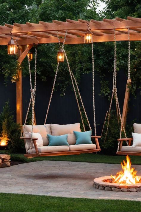 Wooden swing seats with cushions hang from a pergola, facing a lit fire pit in a landscaped backyard. Swings Around Fire Pit Ideas, Bonfire Pit Ideas With Swings, Pergola Ideas With Swings, Hammock In Backyard, Fire Pit With Swings Around It, Swings In Garden, Pergola With Swings And Fire Pit, Outdoor Swings For Adults Backyards, Swings Around Fire Pit