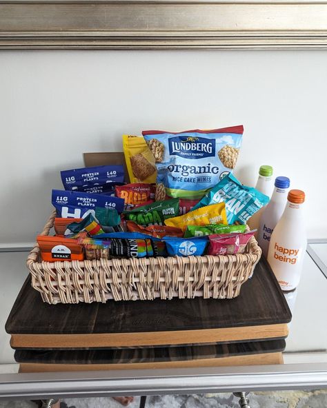 Pantry snacks and food items collected in a basket and placed on a table Happy Apartment, Guest Gift Basket, Hospitality Baskets, Pantry Snacks, Guest Basket, Snack Basket, Walkers Shortbread, Office Snacks, Mexican Snacks