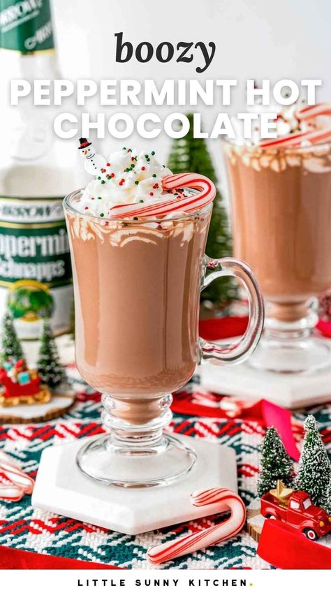 Peppermint hot chocolate served in fancy mugs with whipped cream, and candy canes Christmas Boozy Drinks, Peppermint Snaps Drinks, Peppermint Snapps Drinks, Hot Chocolate Alcoholic Drinks, Elf Dinner, Peppermint Coffee Syrup, Peppermint Hot Chocolate Cocktail, Boozy Hot Chocolate Recipe, Spiked Peppermint Hot Chocolate