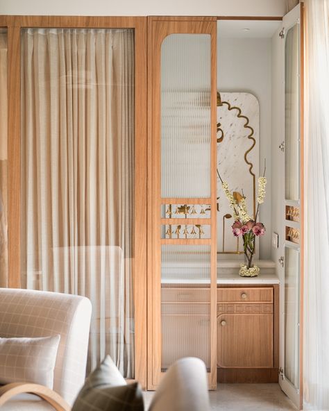 The mandir space of the Kābu home ❤️ When we brought down a bedroom wall to allow for more light in the living-dining spaces, we created a small space for the mandir. Minimal just like the rest of the home but warm and elegant , we conceptualised a marble back panel here with brass inlaid lotuses and religious motifs. A fluted glass door with strings of bells in a cutout in the middle, adds to the pious charm 🥰 . Photo credit: @nayansoni21 . . #studioipsa mandir | puja room | interior... Small Pooja Unit In Living Room, Studio Home Ideas, Puja Room Interior Design, Small Puja Room Ideas, Small Pooja Room In Living Room, Small Mandir Design, Mandir Design Puja Room Modern, Mandir Ideas For Small Space, Modern Pooja Unit