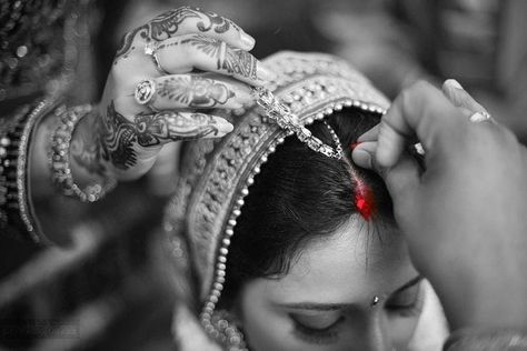 Putting sindoor in hair partition Red is the colour expressing power (Red is the colour which depicts the energy of Sati and Parvati in Indian mythology. Sati is said to be an epitome of ideal Hindu wife who can even sacrifice her life for her husband’s sake. Hindus believe that putting vermillion will bless a woman with ‘Akhand Soubhagya’ from Goddess Parvati.) Sindoor control BP  Sindoor keeps woman calm and healthy Scientifically, a woman puts vermillion where her Ajna Chakra or Brahma Sthana Sindoor Moment Quotes, Sindoor Moment, Indian Wedding Pictures, Indian Wedding Poses, Marriage Photography, Bride Photos Poses, Indian Wedding Photography Couples, Wedding Couple Photography, Indian Wedding Couple Photography