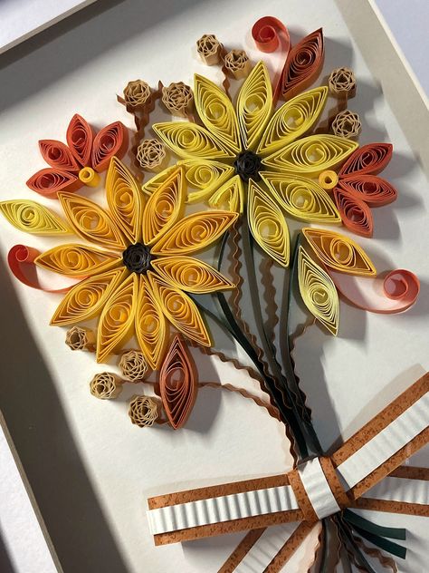 "Autumn Leaves" is a beautiful, autumn themed paper quilled artwork which consists of sunflowers and dried florals. Paper quilled art always acts as a unique gift for birthdays, holidays, anniversaries or house warming.  Each paper strip is shaped and glued to the canvas by hand, once the quilling process is complete, the piece is set into a box frame. Each artwork is packaged carefully with a thank you card and tissue paper, to complete your shopping experience with Grafika! Autumn Quilling Ideas, Fall Quilling Ideas, Quilling Ideas Unique, Fall Quilling, Autumn Leaves Paper, Quiling Paper Art, Quilled Artwork, Autumn Bouquet, Quilling Ideas