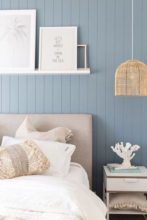 Inspired by the tranquility of coastal aesthetics, this bedroom uses light blue vertical paneling to evoke a sense of seaside calm. The minimalist decor, including the whimsical framed phrases and the rattan lighting, adds to the laid-back, beachy vibe. This blue bedroom design in 2024 captures the essence of a serene beachside escape within the comforts of home. Water Palette, Manly Apartment, Wall Profile, Beautiful Bedroom Colors, Blue Bedroom Design, Bedroom Design Styles, Bedroom Plan, Feature Wall Bedroom, Beachy Room