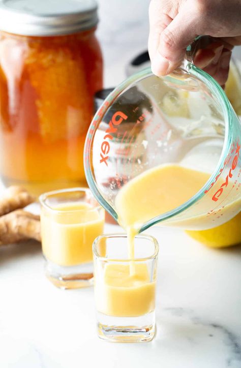 Pouring yellow liquid from a glass measuring pitcher into two shot glasses. Ginger Health Shots, Diy Ginger Shots, Ginger Shots Recipe, Healthier Deserts, Herb Infused Honey, Ginger Shot Recipe, Lemon Shots, Ginger Shots, Christmas Main Dishes