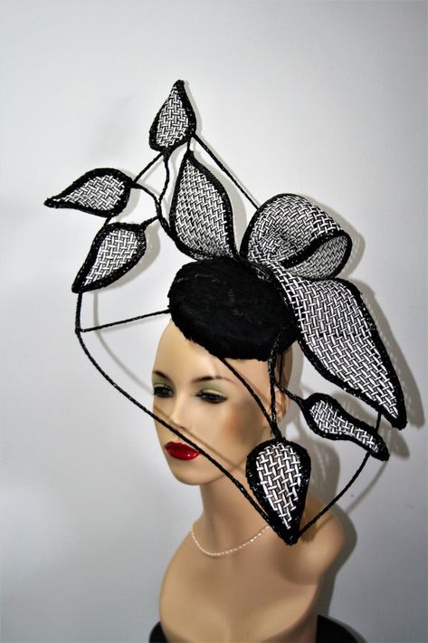 This statement headpiece features a button base covered with black fabric with sequins, ribbon and lace woven through it. It has a wired frame design covered with black braid and is finished off with a large black and white weave bow and wired leaves also edged with black braid. It is lightweight and held in place with elastic and bobbie pins.  |  Hat Shape: Freeform |  Colour: Black, White |  Features/Construction: Sinamay, Straw, Spring/Summer |  Condition: New |  Price: 220 AUD  |  Milliner: Donut Hat, Statement Headpiece, Cup Head, Lace Weave, Black Fascinator, Black White Abstract, Different Hats, Head Pieces, Yellow Hat