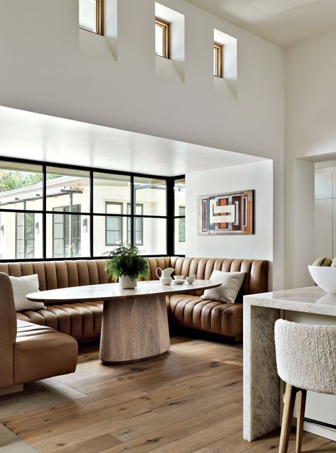 Defining the breakfast nook, a banquette made by Briley’s Upholstery Shop features leather sourced from Canvas Showroom, its tufting echoing the fluted plaster details in the kitchen and family room. Edwood Studio designed the oval white oak pedestal table. Small Dining Banquette, Fluted Plaster, Breakfast Table Decor, Seating In Kitchen, Banquette Ideas, Modern Breakfast Nook, Dining Room Nook, Luxe Magazine, Dining Booth