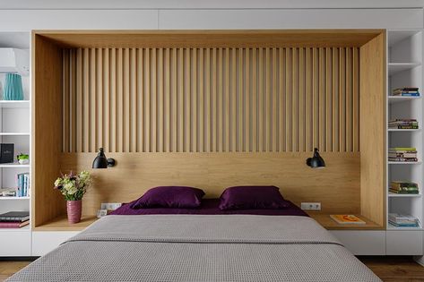 The design of this custom wall in a modern bedroom, combines wood and white details, and integrates the bed frame, a headboard, side tables, and bookshelves. #BedroomDesign #ModernBedroom #Headboard #Bookshelves Mattress Room, Headboard With Shelves, Built In Bed, Stylish Apartment, Slatted Headboard, Headboard Wall, Side Table Design, Lighting Design Interior, Wood Bedroom