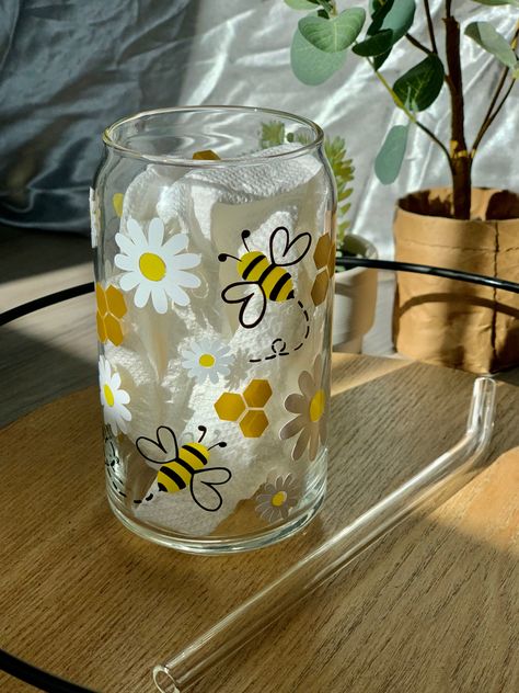 Black and yellow honey bee with white daisies and gold honey comb on a can glass. Set on a tray with a glass straw next to the glass cup and a prop tree in the background. Beer Glass Design, Glass Iced Coffee Cup, Glass Tumbler Design, Painting Glass Jars, Idee Cricut, Cute Coffee Cups, Glass Painting Designs, Glass Bottle Diy, Diy Glass Bottle Crafts