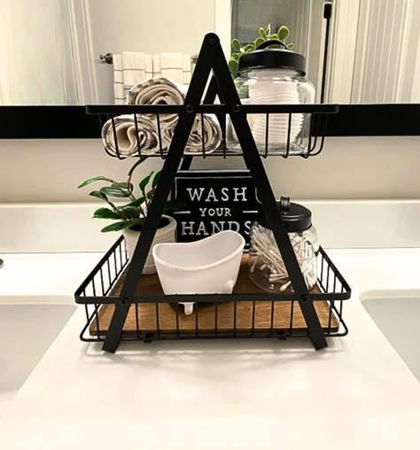 "This multi-purpose, Farmhouse-style countertop organizer is an attractive decorative accent and an effective organizer for the bathroom or any room of the house! This best-seller has more than 75, 5-star reviews!  The rustic Two-Tier Decorative Basket will elevate your bathroom counter however you style it. Check out the reviews for inspiration from our customers who love to fill it with rolled towels, filled jars, cosmetics, lotions, candles, small plants and decorative signs.  DETAILS Dimensi Farmhouse Bathroom Vanity Decor, Towel Organizer Bathroom, Above Toilet Towel Storage, Bathroom Basket Decor, Bathroom Setup Ideas, Main Bathroom Ideas Decor, Black And White Bathroom Decor Ideas, Bath Towel Storage Ideas, Decorate Bathroom Ideas