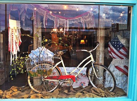 Summer window display. Vintage bicycle, American flag, string lights. Thrift Store Display Ideas, Farms Market, Bicycle Display, Retail Window Display, Bike Craft, Summer Window Display, Summer Display, Bookstore Ideas, Store Display Ideas