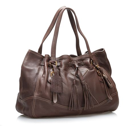 Product Details: Brown Prada Cervo Drawstring Leather Tote. This tote bag features a leather body, flat straps, an open top with magnetic with a tassel drawstring closure, and an interior zip pocket. 11.8" L x 16.1" W x 6.1" D, 6.3" drop. Condition: . Good. Exterior Front Discolored, Out Of Shape, . Exterior Back Out Of Shape, . Exterior Bottom Out Of Shape, . Exterior Bottom with Other. Exterior Handle Out Of Shape, . Exterior Corners . Exterior Side Out Of Shape, . Exterior Top Out Of Shape, . Interior Lining with Other. Practical Attachment Scratched. Zipper Scratched. Please note this is a item that may display signs of wear consistent with the condition listed above and shown in photos. Designer Revival this is an Brown Prada Cervo Drawstring Leather Tote or . Learn more about our ati Miuccia Prada, Diaper Backpack, Vuitton Bag, Open Top, Casual Backpack, Fashion Labels, Prada Bag, Tote Handbags, Leather Tote