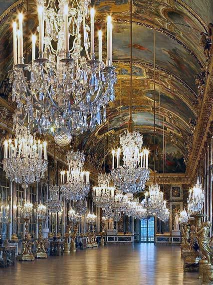 Chandeliers at Palace of Versailles's Hall of Mirrors.   In the 1670s Louis XIV built the Grand Apartments of the King and Queen, whose most emblematic achievement is the Hall of Mirrors designed by Mansart, where the king put on his most ostentatious display of royal power in order to impress visitors. The Chapel and Opera were built in the next century under Louis XV. Versailles Hall Of Mirrors, Chateau Versailles, Hall Of Mirrors, Palace Of Versailles, Chateau France, Louis Xiv, Ancient Architecture, The Ceiling, Alam Yang Indah