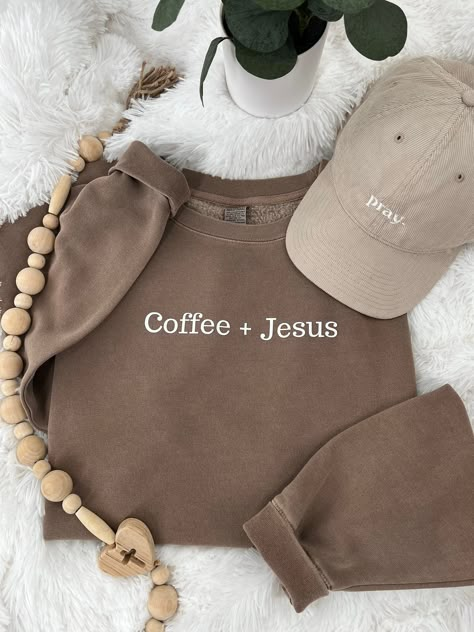 Coffee + Jesus Premium sweatshirt perfect for those chilly mornings and evenings.  Our sweatshirt is great for Christian women and men that love both coffee and Jesus.  Size up for oversize fit.  Coffee Brown Premium Sweatshirt: Female model wearing sweatshirt 5'10" 185 lb 9 oz./yd² (US) 15 oz./L yd (CA), 80/20 cotton/polyester blend with 100% cotton face, 30 singles Standard fit Split stitch double needle sewing on all seams Twill neck tape 1 x 1 ribbing at neck, cuffs and waistband Woven label Sweatshirt Gift Ideas, Made To Worship Sweatshirt, Saying Sweatshirts, T Shirt Over Sweatshirt Outfit, Neutral Wardrobe Aesthetic, Christian Boutique Ideas, Bible Verse Sweatshirts, Christian Sweatshirts For Women, Cute Christian Sweatshirts