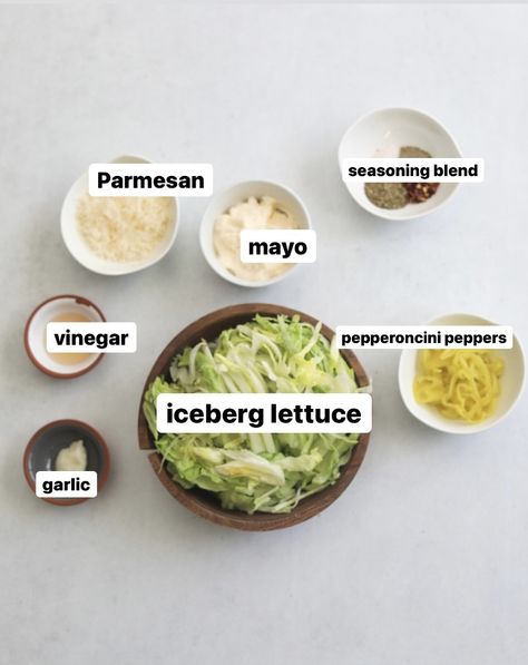 Flat lay of recipe ingredients for Italian Grinder. In small white bowls, seasoning blend, parmesan, mayo, pepperoncini peppers. In a medium sized wooden bowl is iceberg lettuce. In two small white and grey bowls is garlic and vineagar. Grinder Sandwiches Ingredients, Grinder Lettuce Mixture, Lettuce For Sandwiches, Sandwich With Chips Inside, Grinder Sauce Recipe, Grinder Salad Dressing Recipe, Grinder Dressing Recipe, Grinder Salad Recipe, Italian Grinder Salad Sandwich