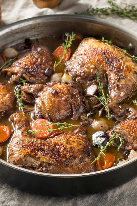 Jamie Oliver Slow Cooker Coq Au Vin is made with Pinot Noir, thick-cut bacon, chicken thighs, crimini mushrooms, shallots, garlic, carrots, chicken broth, tomato paste, fresh thyme, bay leaves, white pearl onions, unsalted butter, and flour. This hearty Slow Cooker Coq Au Vin recipe creates a hearty dinner that takes about 8 hours to prepare and can serve up to 5 people. Coq Au Vin Slow Cooker, Chicken Coq Au Vin Recipe, Slow Cooker Coq Au Vin, Carrots Chicken, Coq Au Vin Recipe, Garlic Carrots, Bacon Chicken, Crimini Mushrooms, Pearl Onions