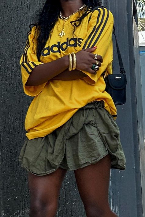 Effortlessly sporty and chic: pair your favorite Adidas yellow jersey with a vibrant green skirt for a casual yet stylish look. Complete the outfit with gold jewelry to elevate your sporty style. Perfect for any occasion! 🌟 #JerseyAndSkirtOutfit #SportyFashion #CasualChic #AdidasFashion #StreetStyle #WomensFashion #jerseyoutfitblackwomen Yellow Adidas, Trendy Bottoms, Look Festival, Jersey Outfit, Yellow Outfit, Looks Black, Sporty Outfits, May 22, Girly Outfits