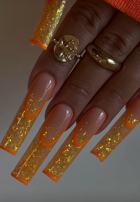 Orang And Gold Nails, Orange And Glitter Acrylic Nails, Orange Winter Nails, Orange And Gold Nails Acrylic, Metallic Orange Nails, Orange Glitter Nails Acrylic, Orange Nails With Rhinestones, Orange Christmas Nails, Orange Nail Inspo Acrylic