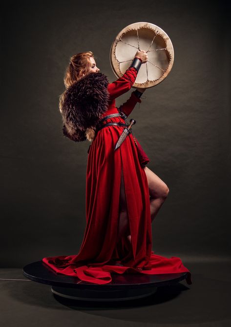 Viking woman wearing a red dress, with fur, playing a shamanic drum Red Viking Wedding Dress, Irish Wedding Traditions Handfasting, Nordic Wedding Dress, Viking Bride, Viking Wedding Dress, After Wedding Dress, Irish Wedding Traditions, Nordic Wedding, Irish Dress