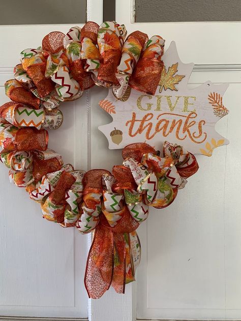 Welcome in fall and your door or inside your home with this stunning 21" Give Thanks Autumn Wreath! The bright fall colors will make you feel like the changing of the leaves is happening right in your home. Purchase your wreath today while supplies last.  PLEASE NOTE: RIBBONS MAY NOT BE THE SAME AS PICTURED due to availability.  Product Dimensions: 21L x 21W x 3.5D Product Weight: 12.5 oz   Product Material: ribbon, MDF, wire wreath, chenille stem, burlap fabric, glue Bright Fall Colors, Foliage Decor, Fall Thanksgiving Wreaths, Home Purchase, Holiday Deco, Thanksgiving Wreath, Pretty Wreath, Thanksgiving Theme, Wire Wreath