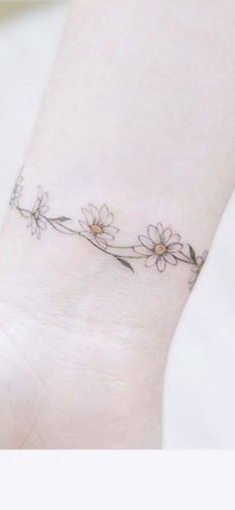 Daisy Ring Tattoo, Daisy Chain Anklet Tattoo, Daisy Bracelet Tattoos For Women, Daisy Chain Bracelet Tattoo, Anklet Tattoos Wrap Around Flower, Daisy Bracelet Tattoo, Flower Anklet Tattoos, Minimal Daisy Tattoo, Daisy Chain Tattoo Ankle