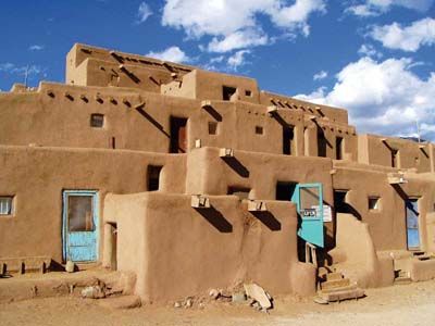 The Taos Pueblo in northern New Mexico is the oldest continuously occupied structure on the continent. Dating back to a.d. 1000, its adobe walls today house about 150 Taos Native Americans who maintain the ancient traditions of their ancestors. The Pueblo is not a historical artifact or a re-creation; it is an actual town that offers a fascinating introduction to Native American life. Travel New Mexico, New Mexico Style, Taos Pueblo, Blue Doors, Taos New Mexico, Adobe House, Vernacular Architecture, Land Of Enchantment, Natural Building