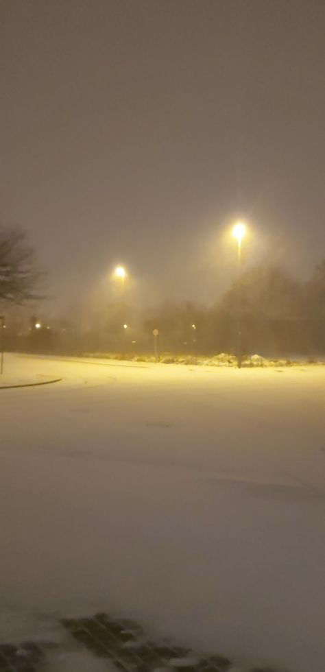 An intersection at night, deep in snow only lit with two street lights Snow Under Street Light, Yellow Street Light, Street Light Aesthetic, Snow Street, Snow Pics, Snow Aesthetic, Night Scenery, Street Lights, Winter Night